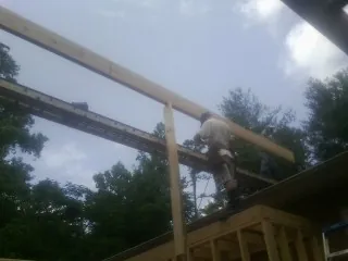 Carpenter setting a ridge beam over a new addition frame — Ice Dam Removal by Roofing Brothers in Laughlintown