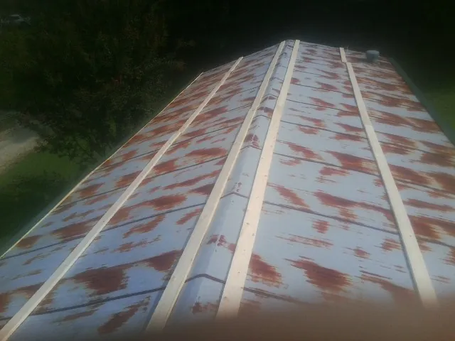 Rusted metal roof panels with new wood purlins before replacement — Storm Damage Roof Repair in Laughlintown by Roofing Brothers