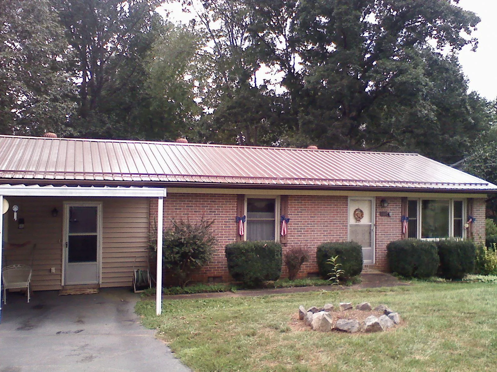 Bronze metal roof and carport on a brick ranch home — Roof Repair work by our crew in Laughlintown